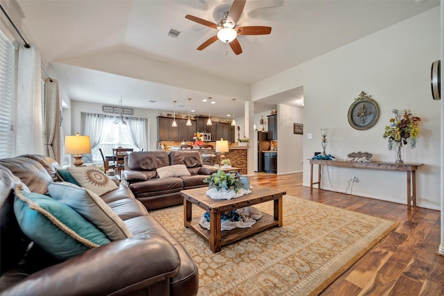 living room with hardwood / wood-style flooring, vaulted ceiling, and ceiling fan