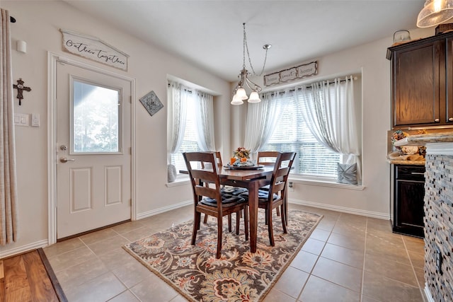 dining room featuring a notable chandelier, a healthy amount of sunlight, and light tile patterned floors