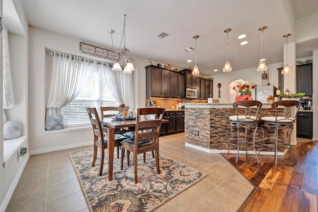 tiled dining space with an inviting chandelier