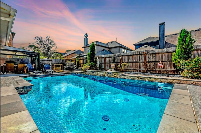 pool at dusk with a patio