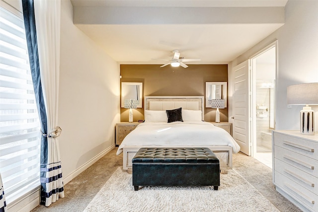 bedroom featuring ensuite bathroom, ceiling fan, and light colored carpet