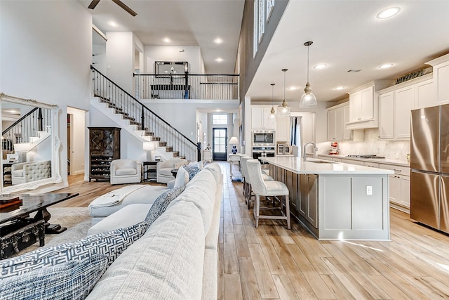 kitchen featuring white cabinets, appliances with stainless steel finishes, pendant lighting, and a large island