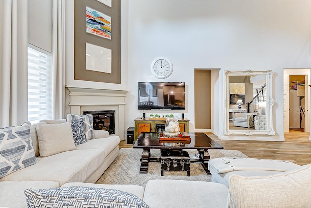 living room featuring a towering ceiling and light hardwood / wood-style flooring