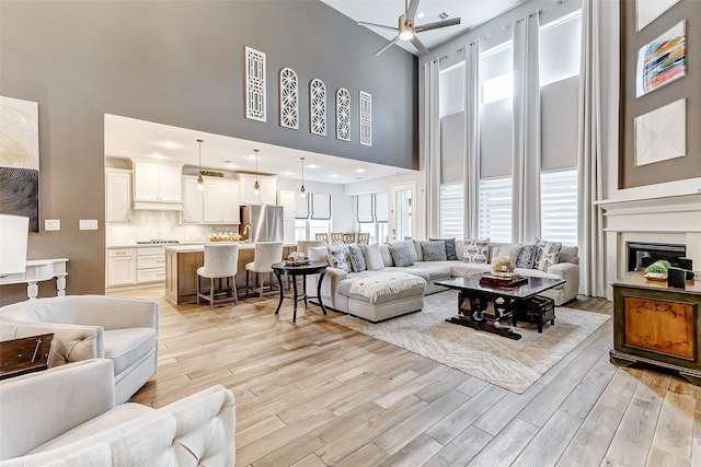 living room featuring a towering ceiling and ceiling fan