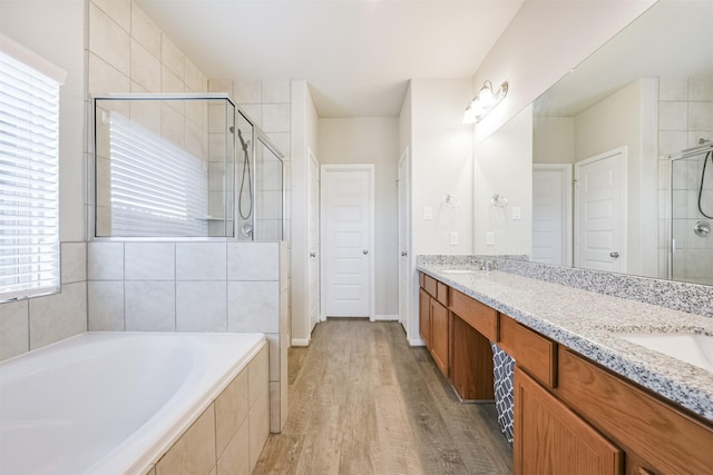 bathroom with separate shower and tub, vanity, and hardwood / wood-style flooring