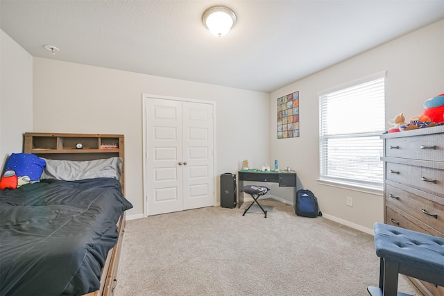 bedroom featuring light colored carpet and a closet