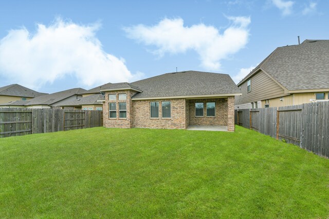 rear view of house featuring a lawn and a patio area