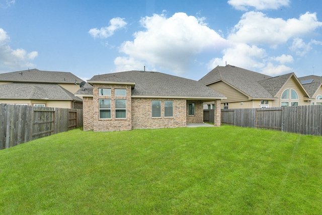 rear view of property featuring a lawn and a patio area