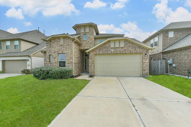 view of front facade featuring a front yard, concrete driveway, fence, and brick siding