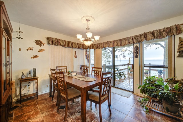 dining area with a water view and a notable chandelier