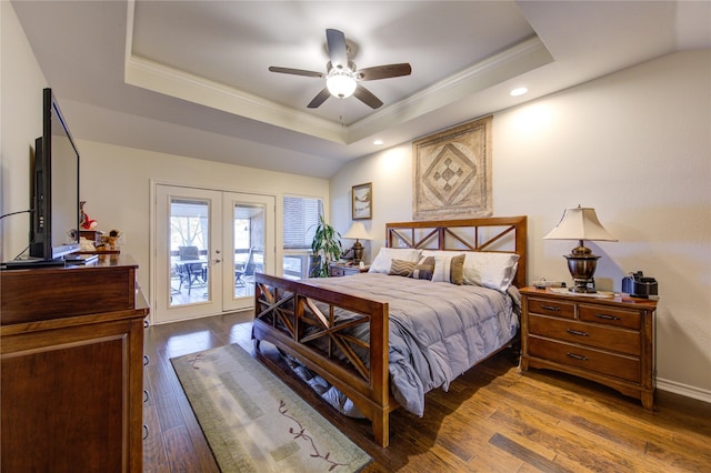 bedroom with french doors, access to outside, a raised ceiling, ceiling fan, and hardwood / wood-style floors