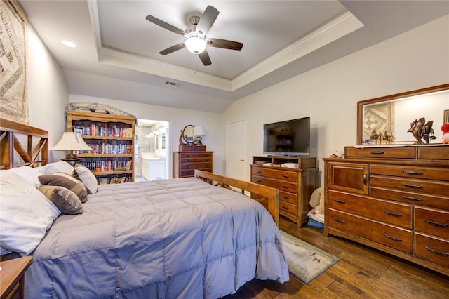 bedroom featuring ensuite bath, ornamental molding, a raised ceiling, ceiling fan, and dark hardwood / wood-style floors