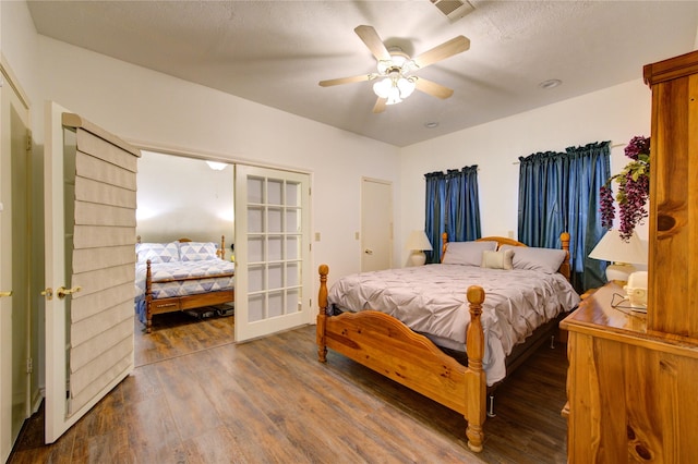 bedroom with ceiling fan, french doors, and dark hardwood / wood-style floors