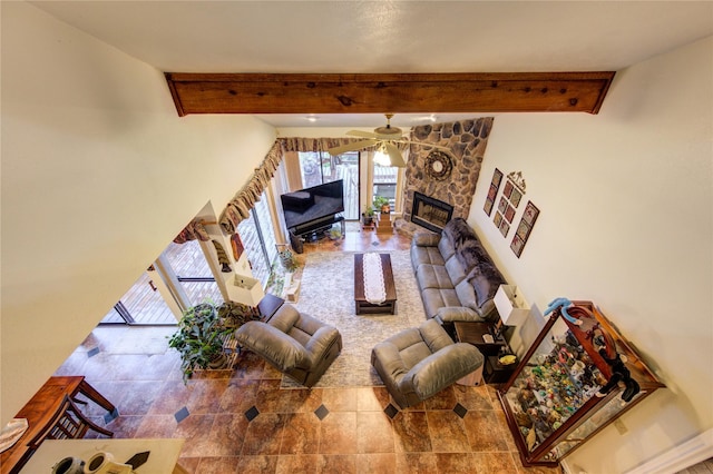 tiled living room with beam ceiling, a stone fireplace, and ceiling fan