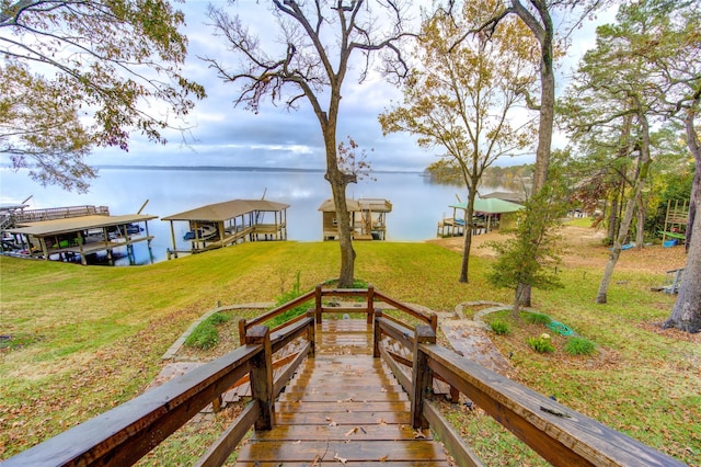 exterior space featuring a lawn and a water view