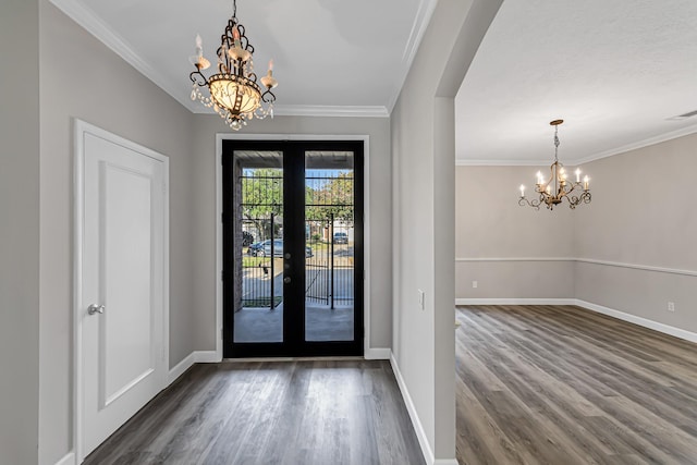 foyer entrance featuring french doors, a chandelier, dark hardwood / wood-style floors, and ornamental molding