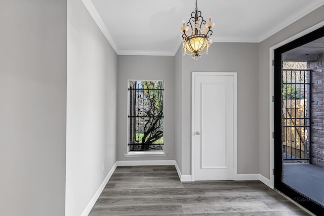 entrance foyer with crown molding, hardwood / wood-style flooring, and an inviting chandelier