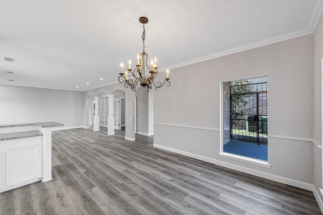 unfurnished living room featuring an inviting chandelier, light hardwood / wood-style flooring, and crown molding