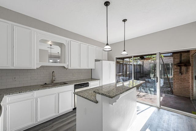 kitchen featuring white cabinetry, sink, tasteful backsplash, white fridge, and dark stone counters