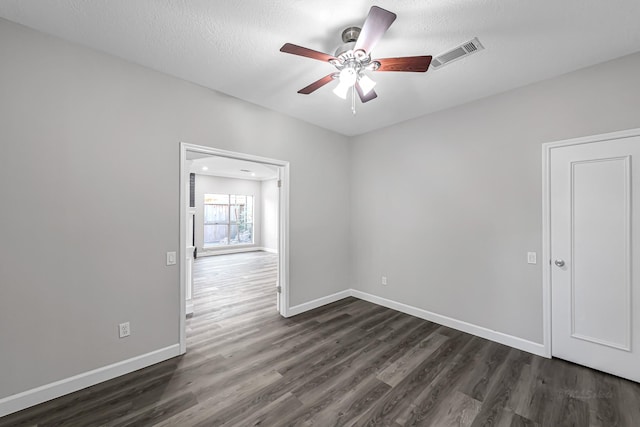 spare room with ceiling fan, dark hardwood / wood-style floors, and a textured ceiling