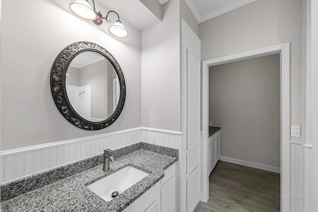 bathroom featuring crown molding, hardwood / wood-style floors, and vanity