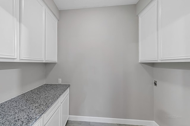 laundry room with electric dryer hookup and cabinets