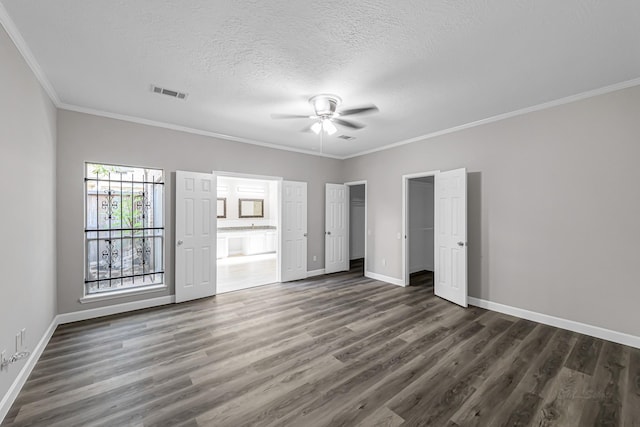 unfurnished bedroom with a textured ceiling, ceiling fan, dark hardwood / wood-style floors, and crown molding