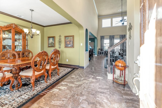 dining room with crown molding, a towering ceiling, and ceiling fan with notable chandelier