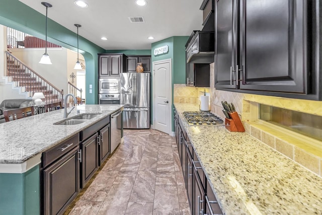 kitchen featuring custom exhaust hood, hanging light fixtures, sink, appliances with stainless steel finishes, and tasteful backsplash