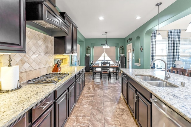 kitchen with custom exhaust hood, sink, appliances with stainless steel finishes, decorative light fixtures, and dark brown cabinets