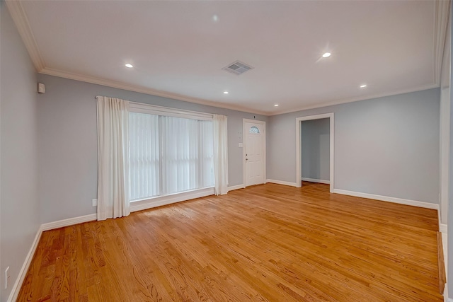 spare room featuring light hardwood / wood-style floors and crown molding