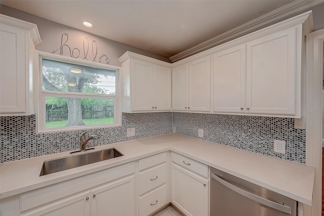 kitchen featuring white cabinets, decorative backsplash, stainless steel dishwasher, and sink