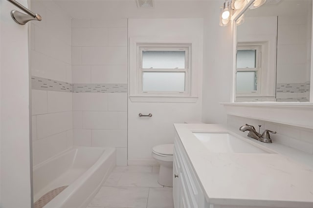 full bathroom featuring tiled shower / bath, vanity, and toilet