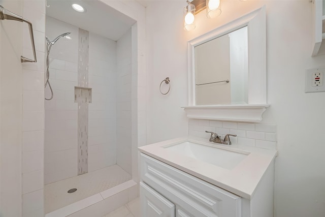 bathroom featuring tasteful backsplash, vanity, and tiled shower