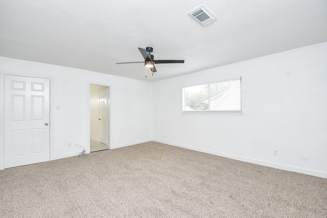 carpeted spare room featuring ceiling fan and a textured ceiling