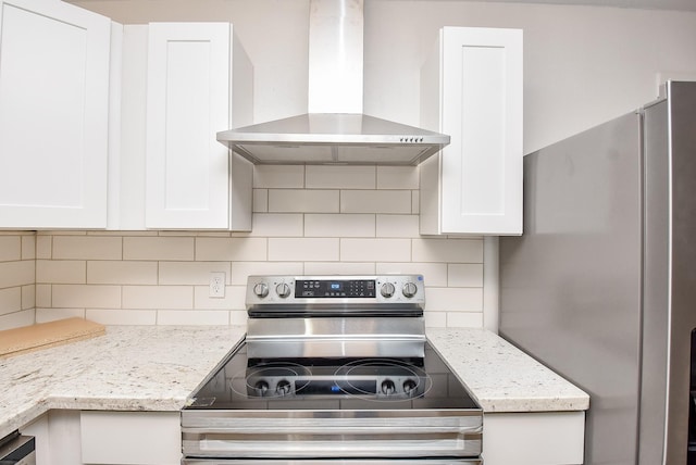 kitchen featuring backsplash, white cabinets, wall chimney exhaust hood, and stainless steel appliances