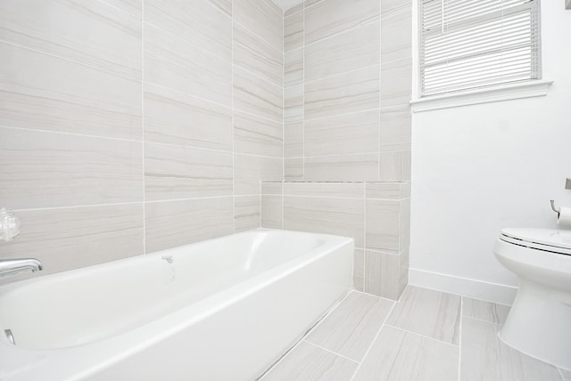 bathroom featuring a bathing tub, tile patterned flooring, and toilet