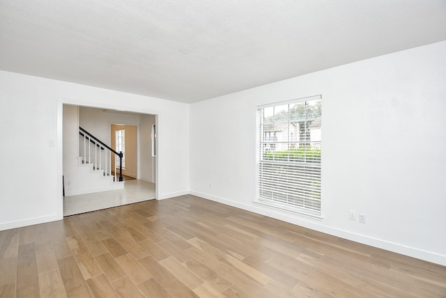 spare room with light hardwood / wood-style flooring and a textured ceiling