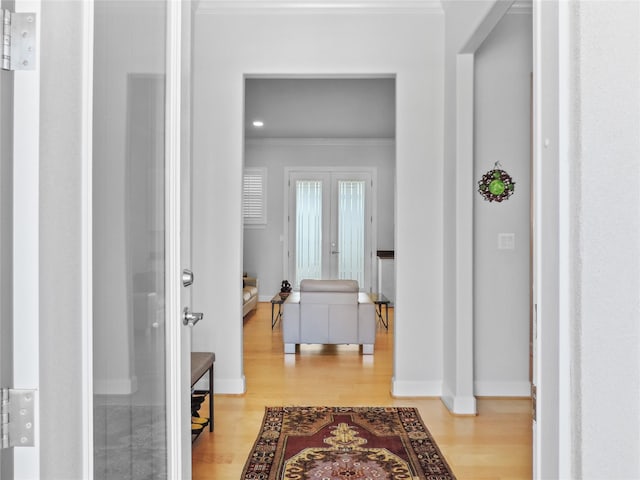 hallway featuring crown molding, french doors, and light hardwood / wood-style flooring