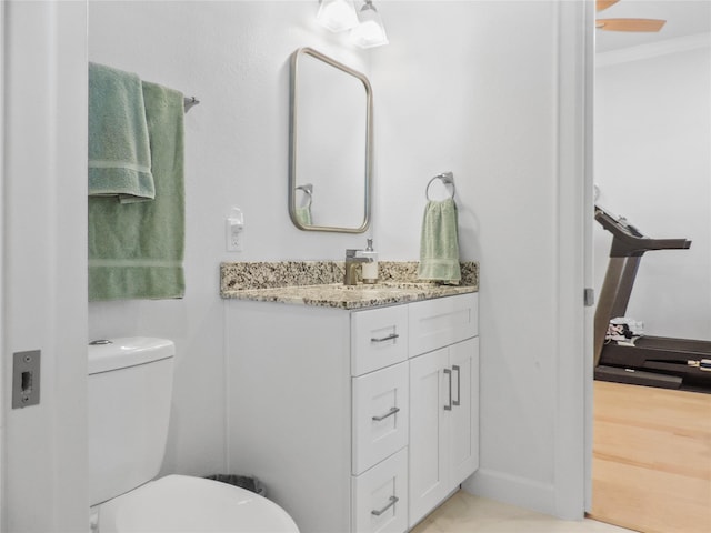 bathroom featuring vanity, toilet, ceiling fan, and ornamental molding