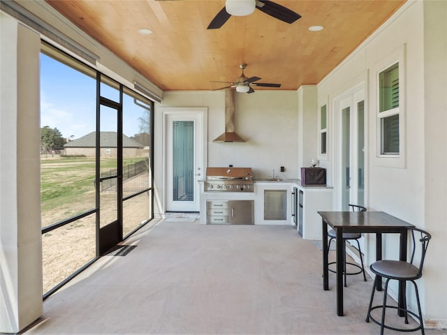 sunroom / solarium with ceiling fan, wooden ceiling, and sink