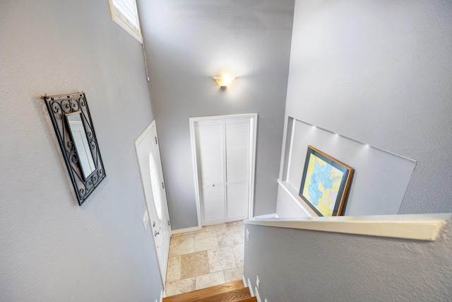 stairway featuring a towering ceiling