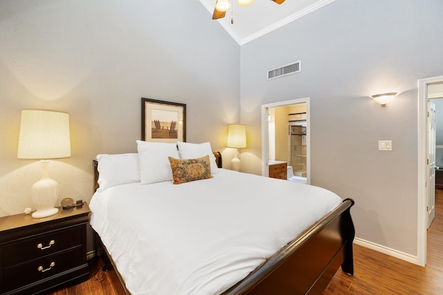 bedroom featuring hardwood / wood-style floors, lofted ceiling, ensuite bathroom, ceiling fan, and ornamental molding