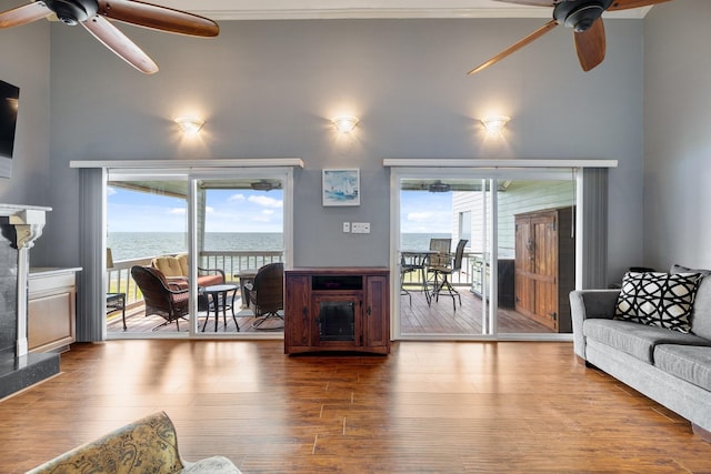 living room with crown molding, hardwood / wood-style floors, a water view, and ceiling fan