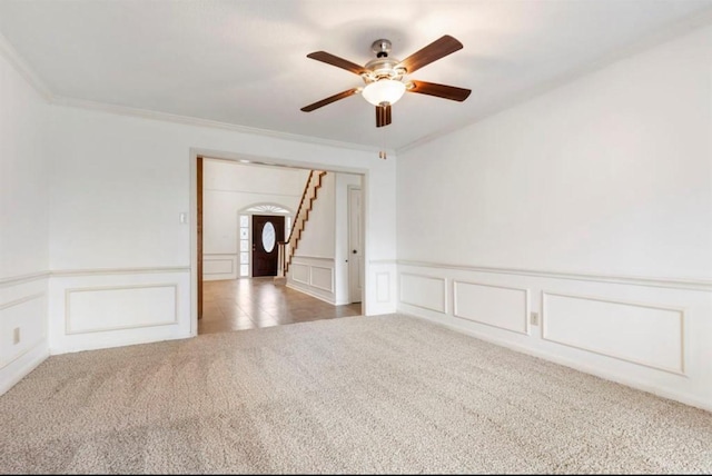 empty room featuring carpet flooring, ceiling fan, and ornamental molding