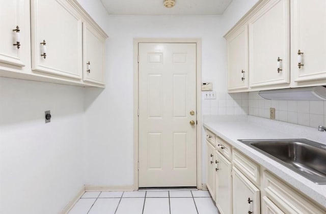 laundry area with light tile patterned floors, electric dryer hookup, and sink