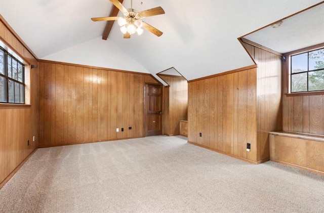 bonus room featuring ceiling fan, wooden walls, and light colored carpet