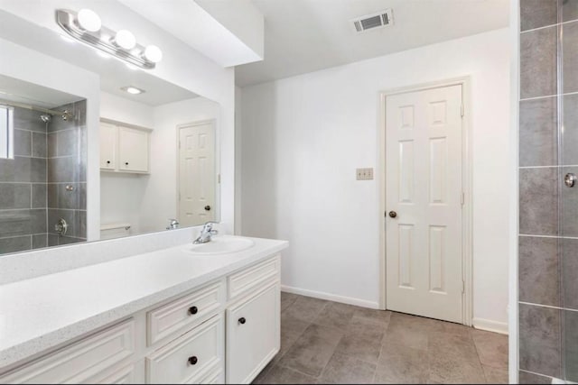 bathroom featuring tiled shower, vanity, and tile patterned floors