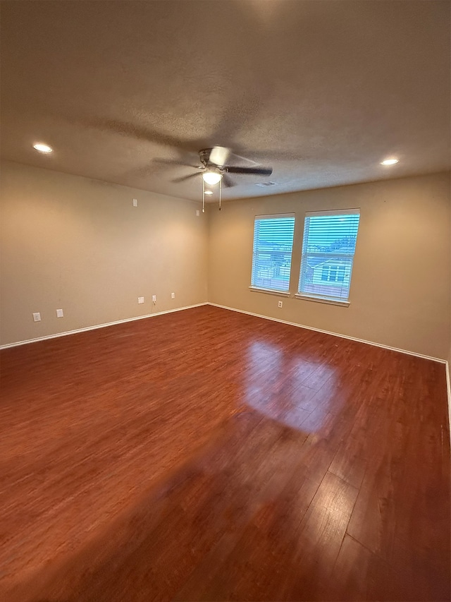 unfurnished room with ceiling fan, wood-type flooring, and a textured ceiling