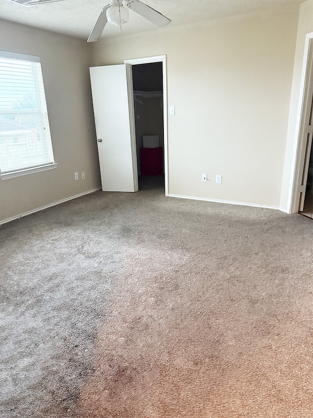 unfurnished bedroom featuring ceiling fan and carpet